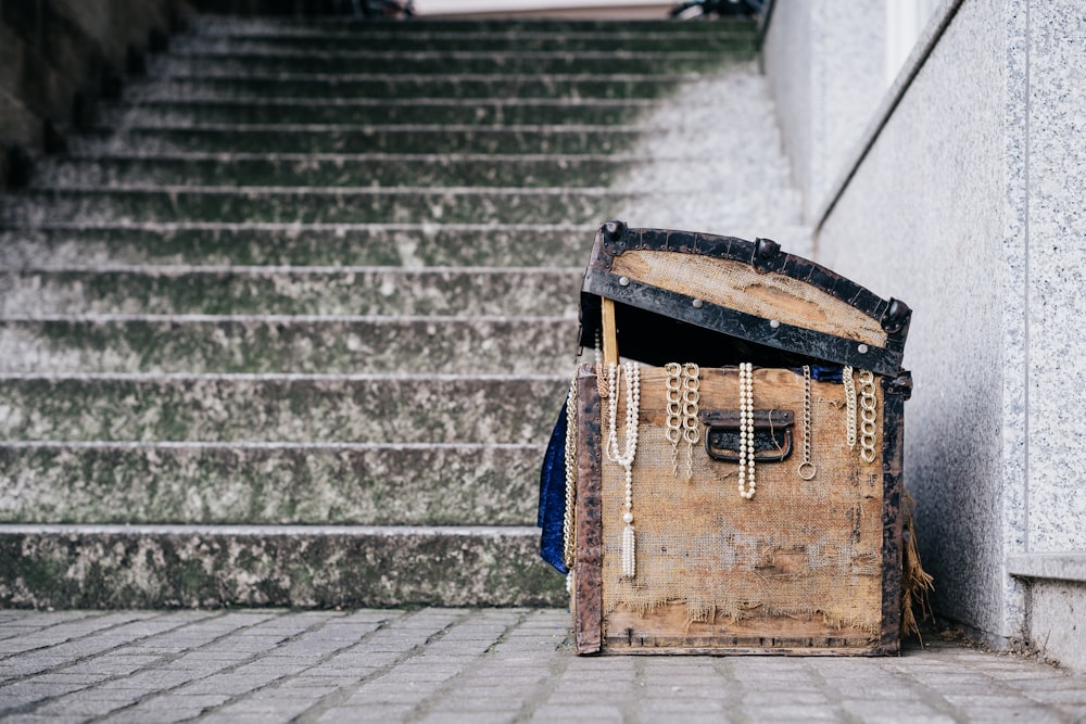 brown jewelry box beside concrete stairs