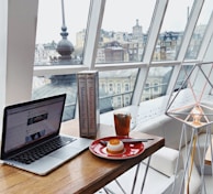 MacBook Pro near food on red plate on brown wooden table