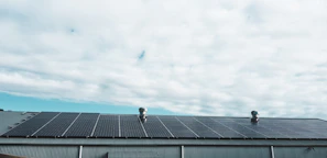 A rooftop covered with shiny solar panels under a clear blue sky