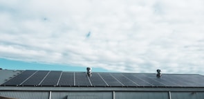 Wide shot of a rooftop covered with solar panels under morning sun.