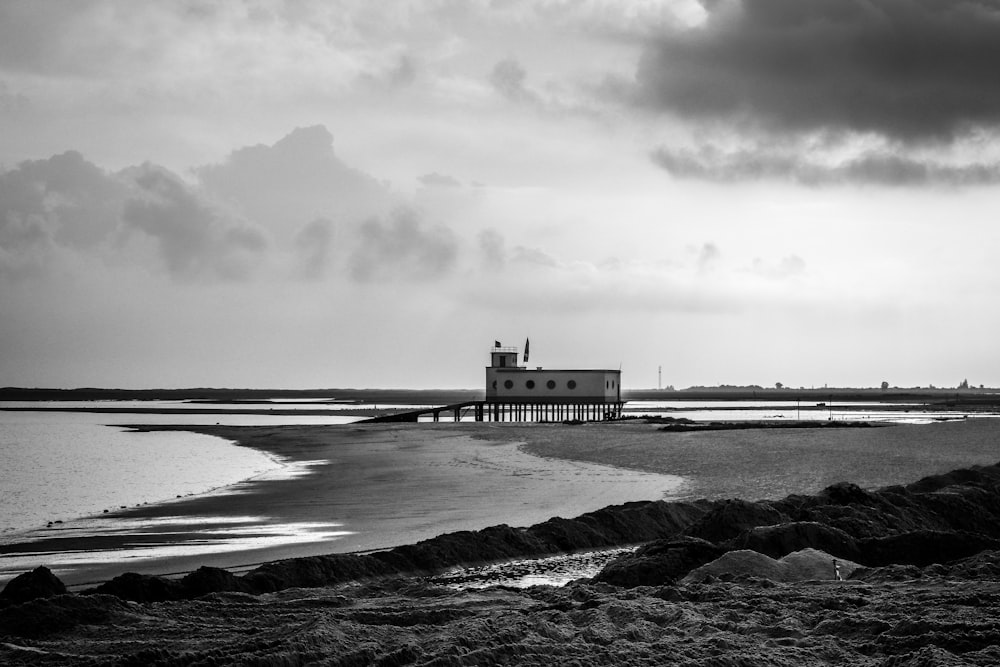 grayscale photography of lifeguard house at shore