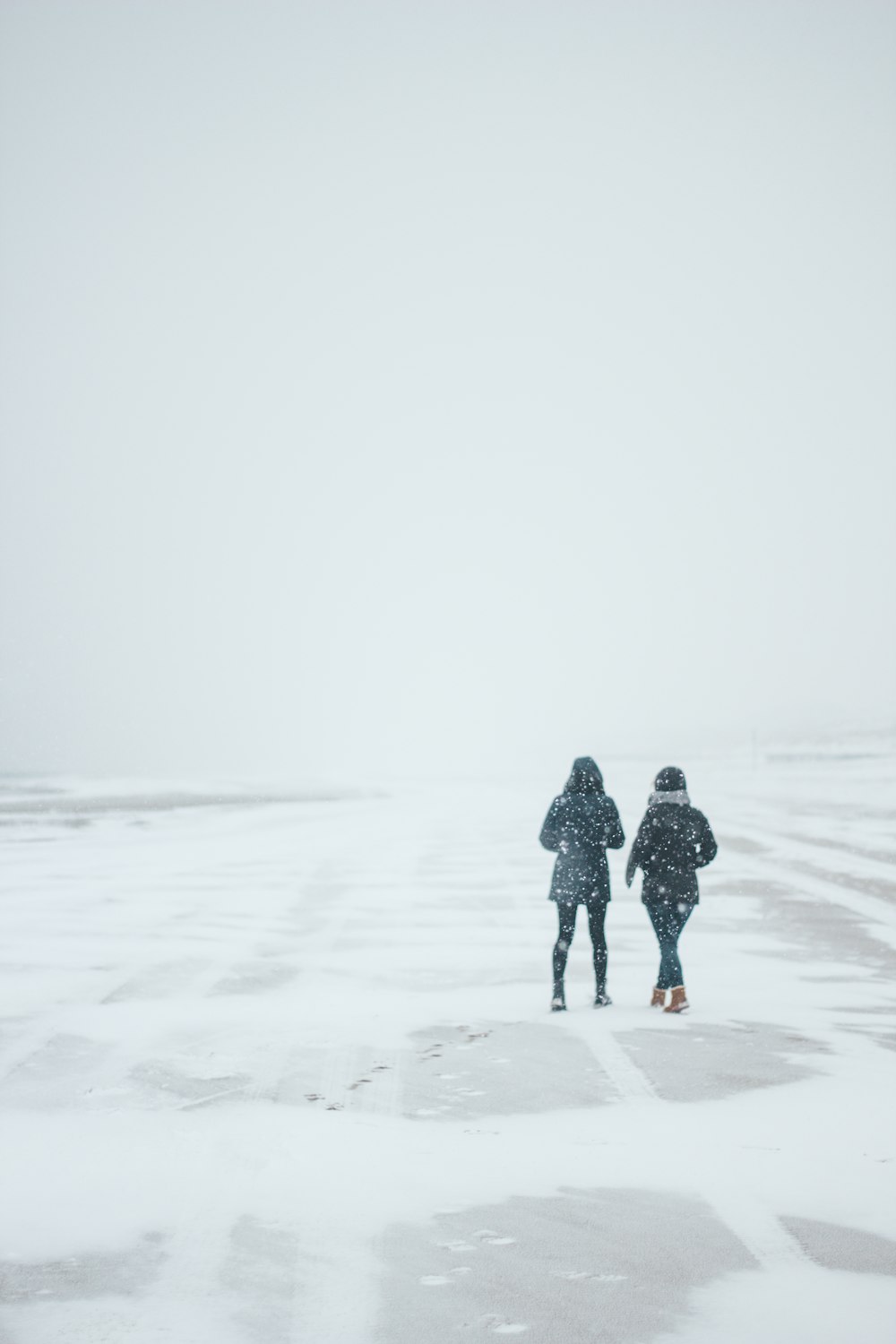 two persons walking on road path