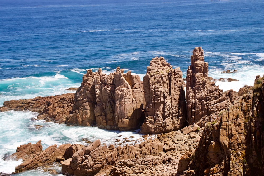 aerial photography of brown rock formations on body of water