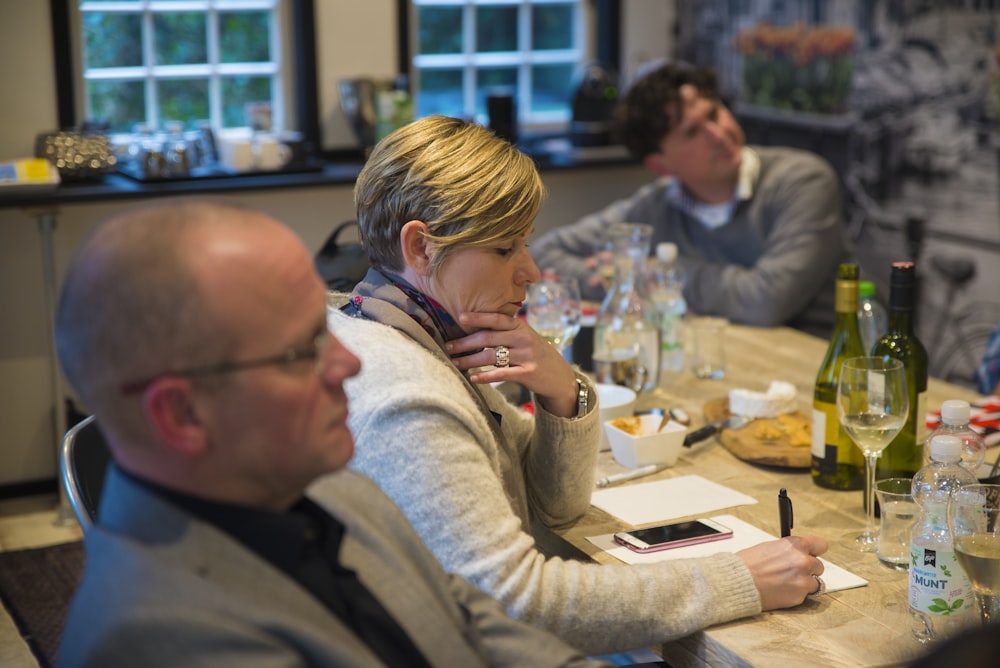 woman in grey sweat shirt writing on table