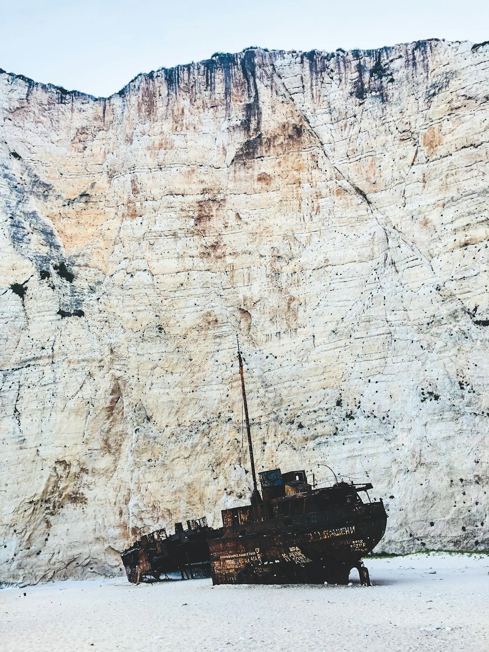 a boat sitting on top of a sandy beach