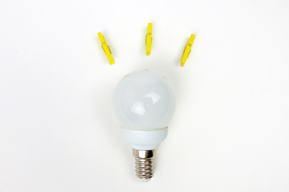 white light bulb near three yellow clips