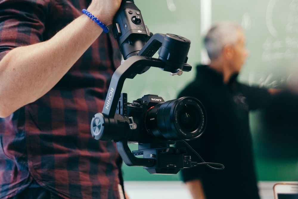 person holding black DSLR camera