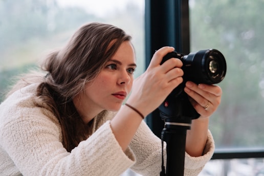 Female real estate photographer adjusting camera settings indoors