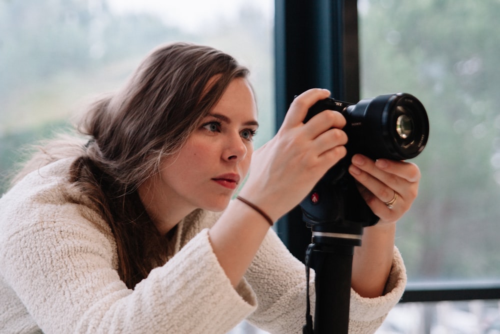 woman taking a photo using black DSLR camera