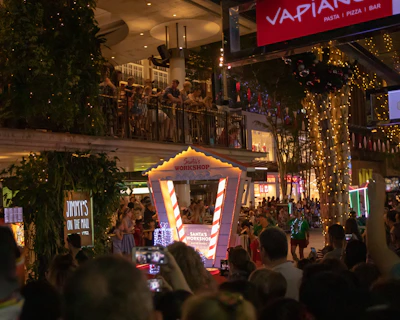 A warmly decorated Christmas event with Santa and magician entertaining excited children gathered around.