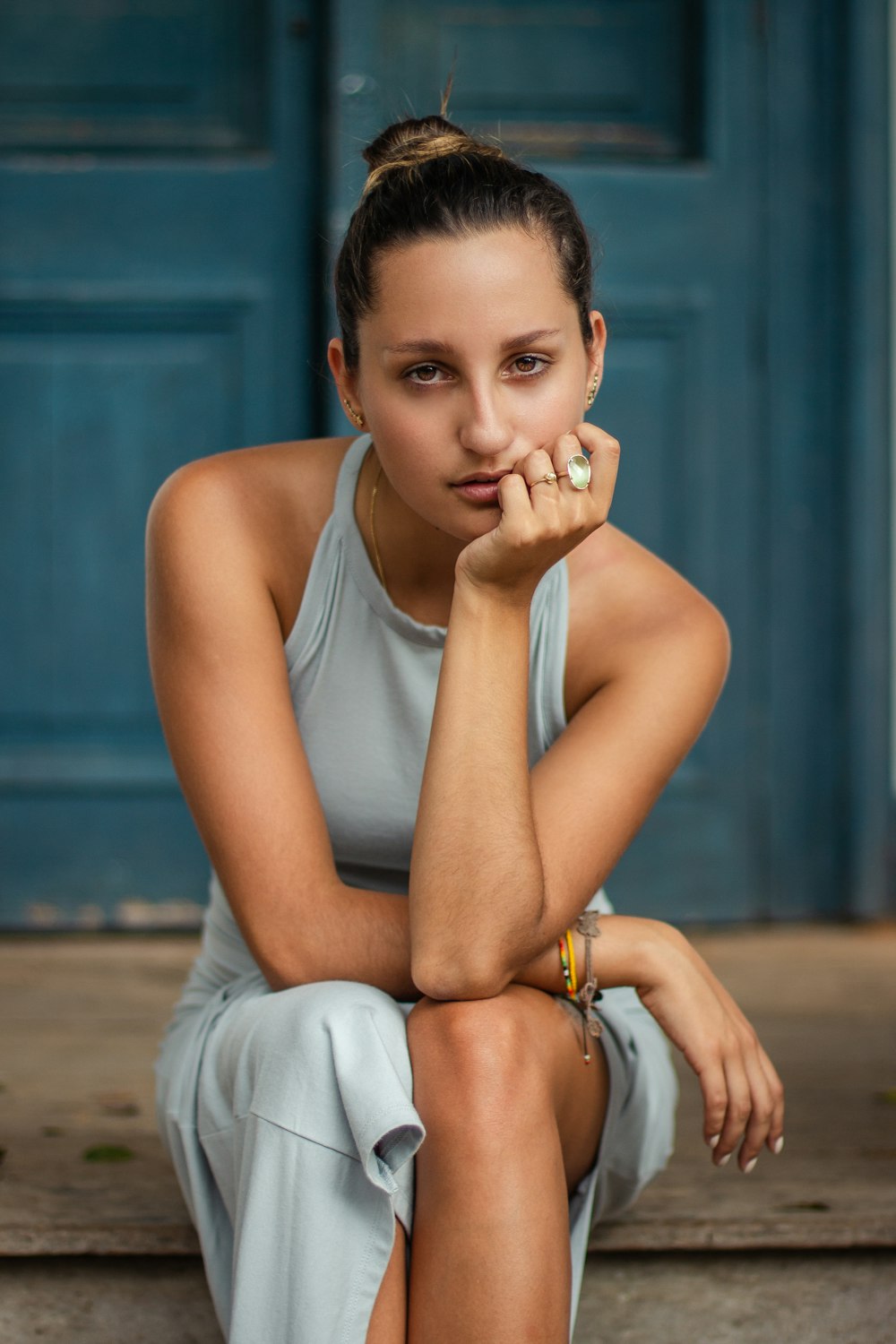 woman wearing dress sitting on brown floor near door