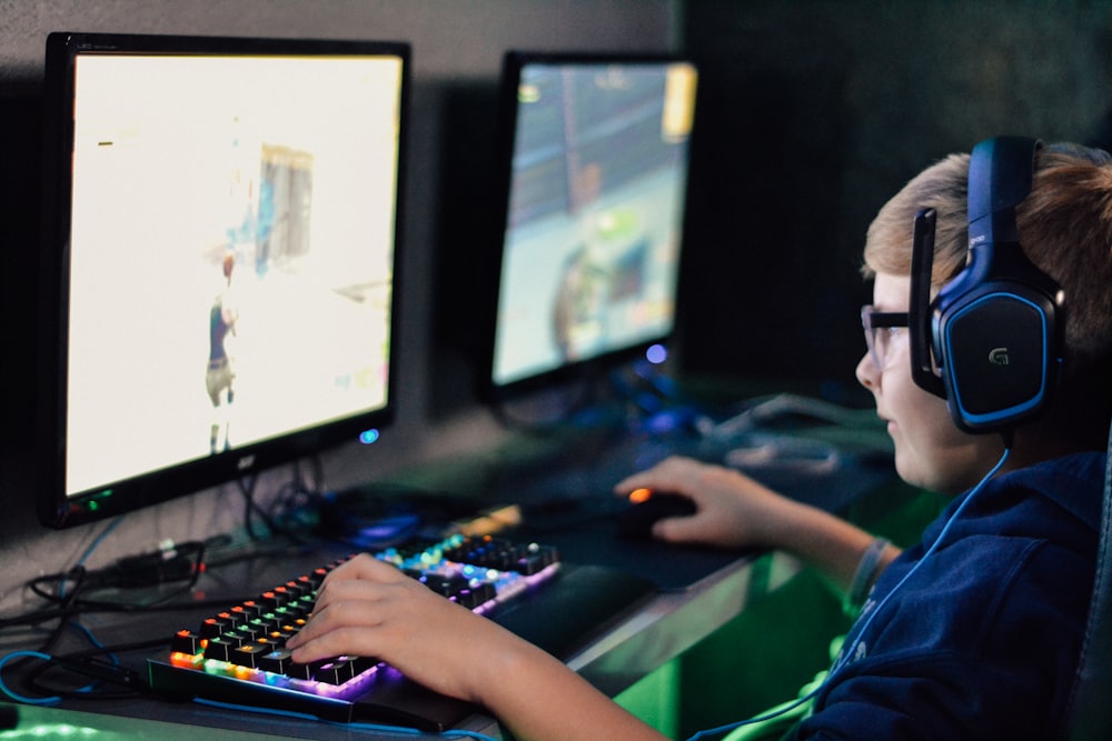 헤드셋을 착용한 소년이 컴퓨터 게임을 하고 있다