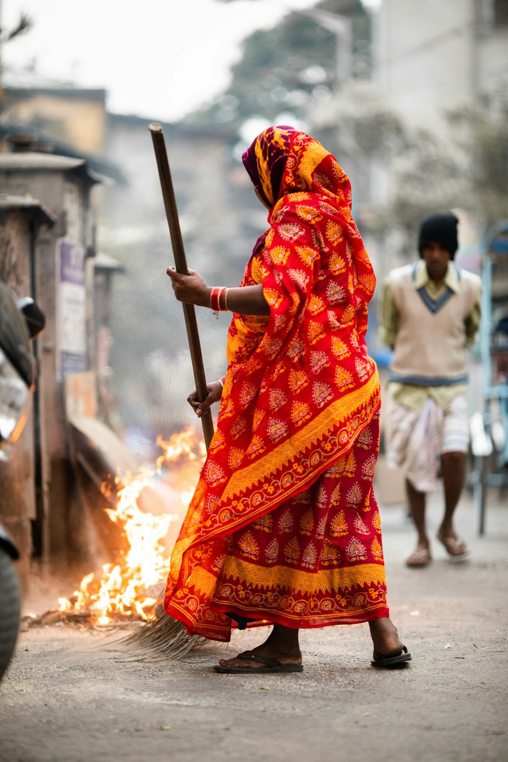 woman wearing orange dress holding broom