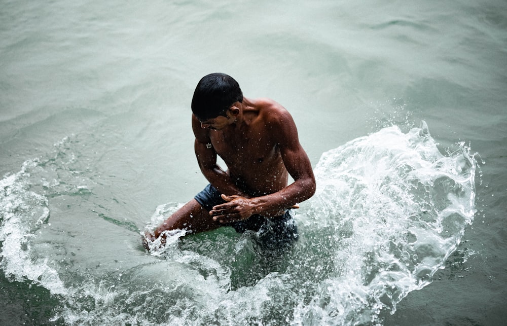 uomo in topless nell'acqua