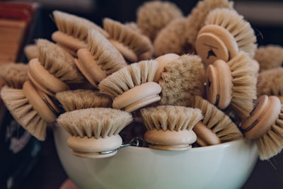 Various brushes and sponges displayed on a wooden table
