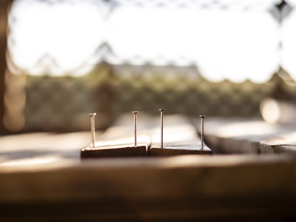 four gray nails on wood