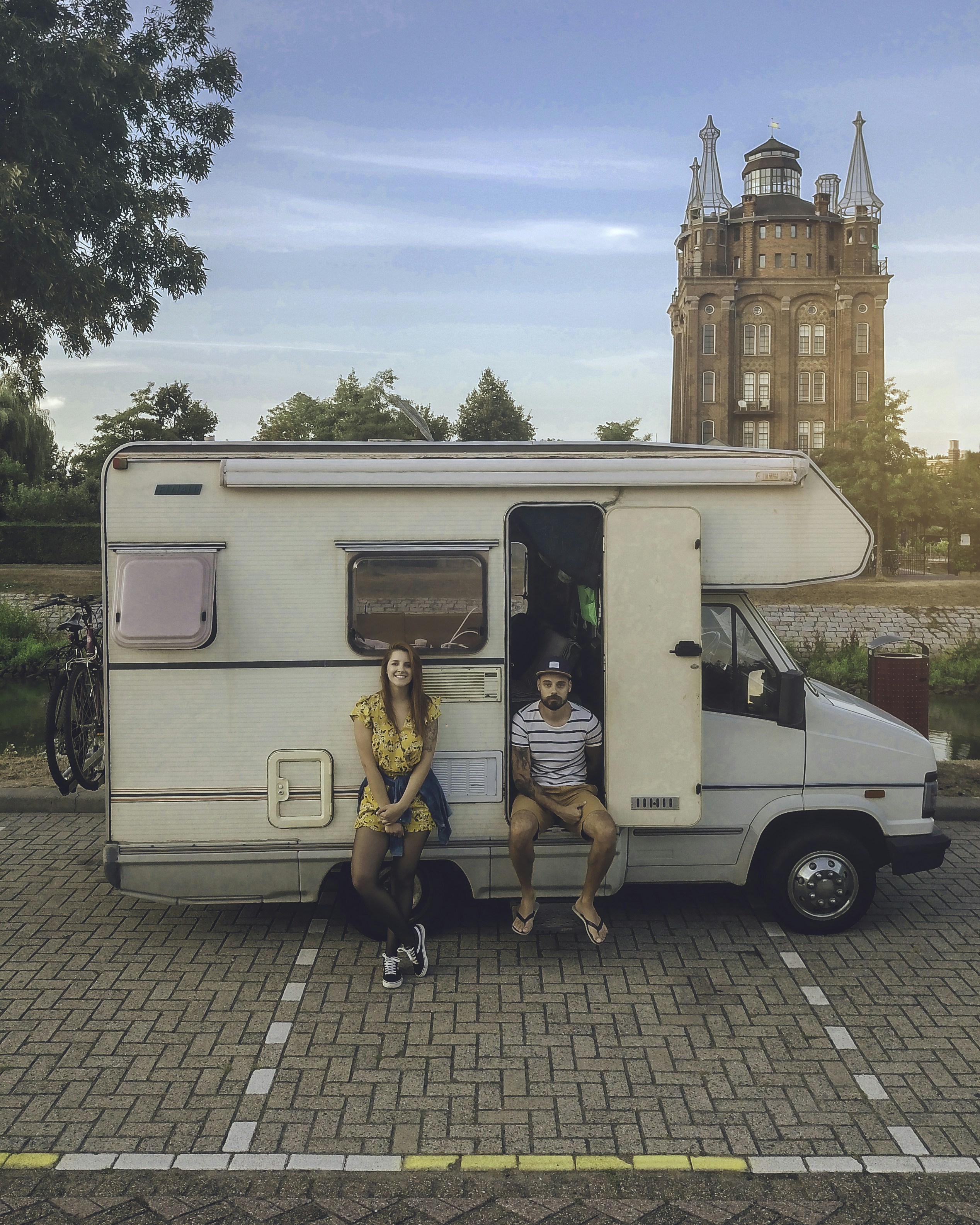 woman leaning and man sitting on RV
