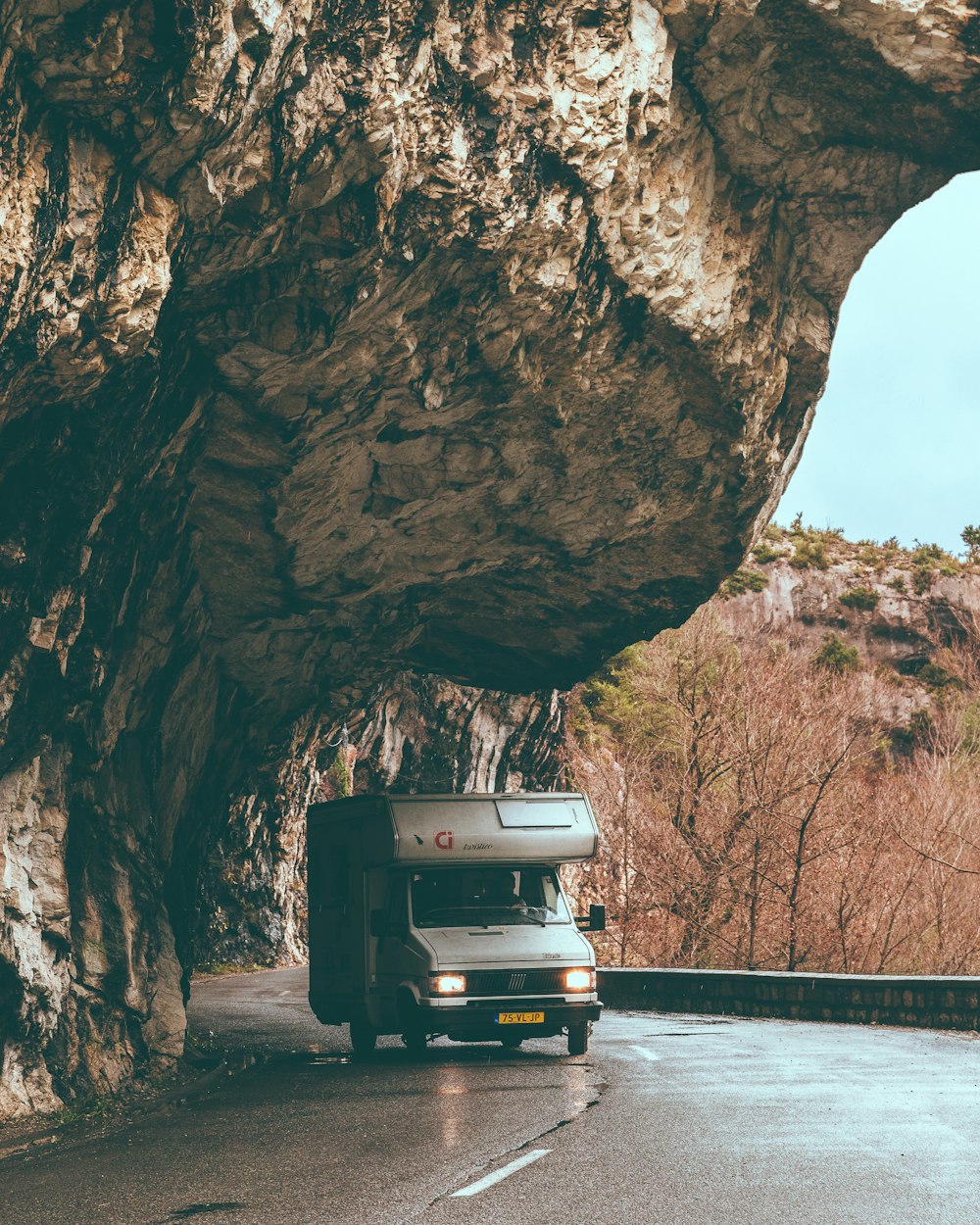 white truck camper on road under rock formation