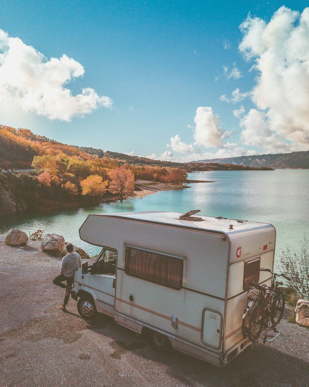 homme s’appuyant sur un camion de camping-car blanc n