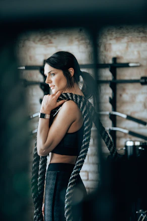 Mujer latina joven entrenando con fuerza en el gimnasio, fuerte y saludable