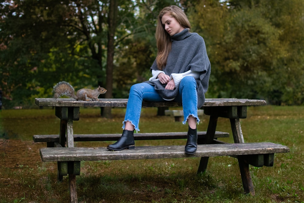 woman in blue denim pants sitting on picnic table outdoor