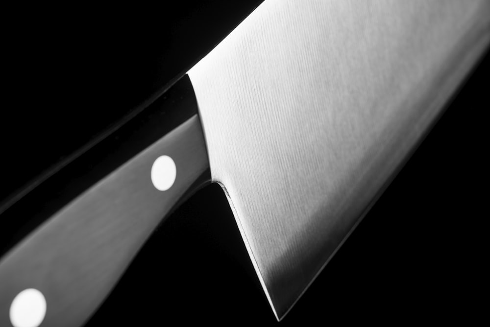 Graustufenfoto eines grauen Hackbeils mit schwarzem Griff