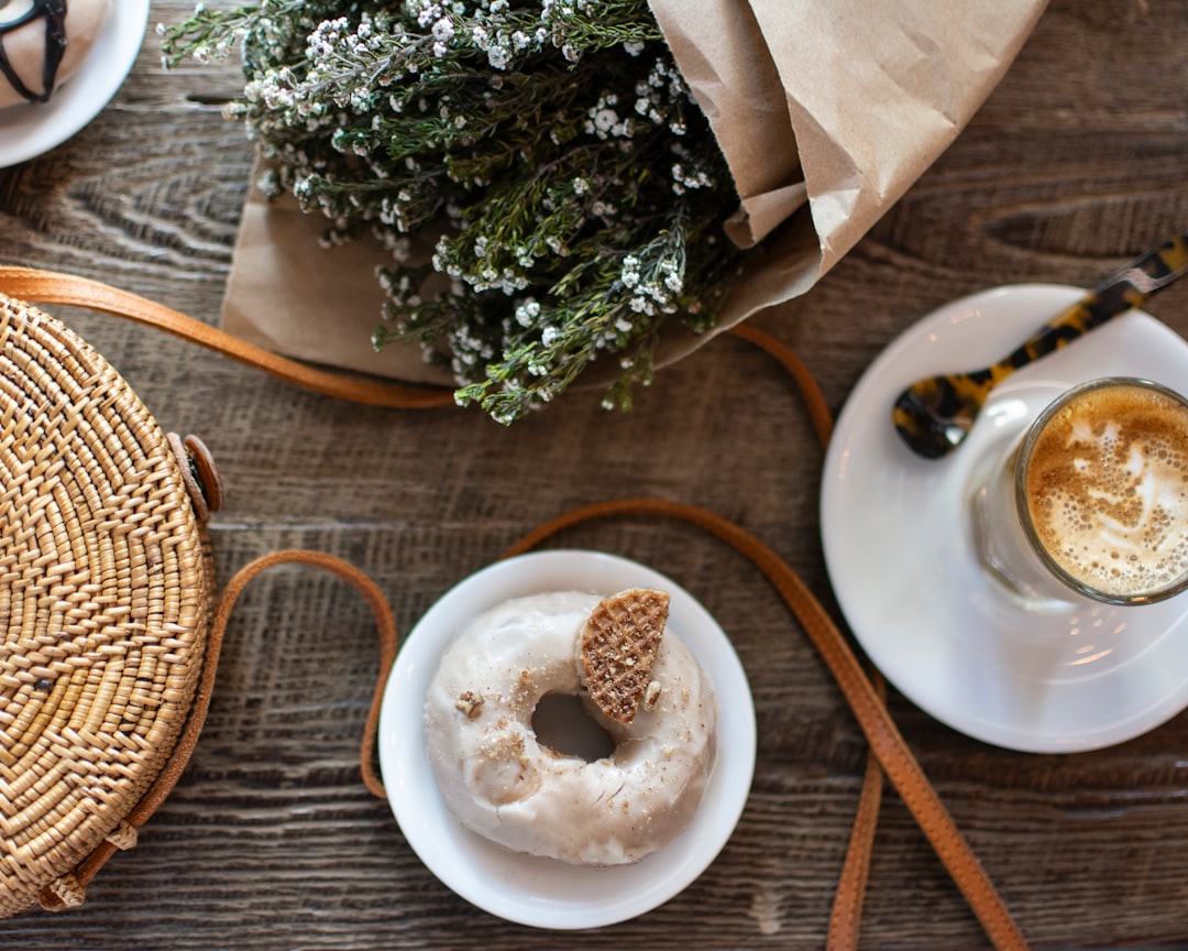 top-view angle photography of doughnut on saucer plate and cup of coffee