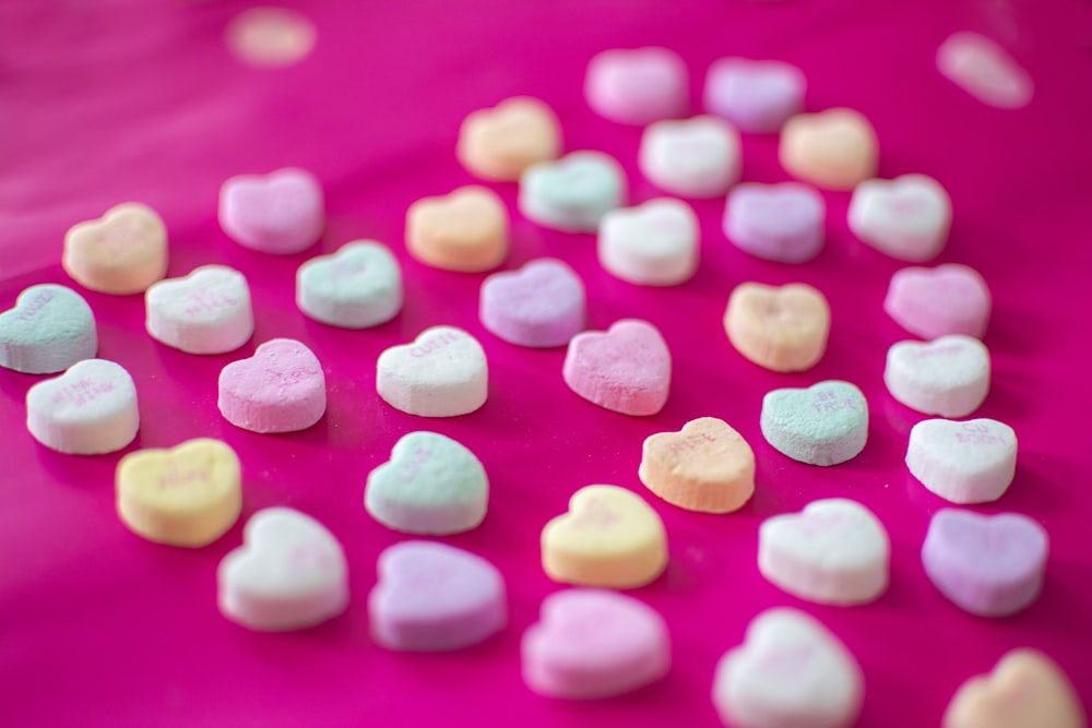assorted-color heart candies on red textile