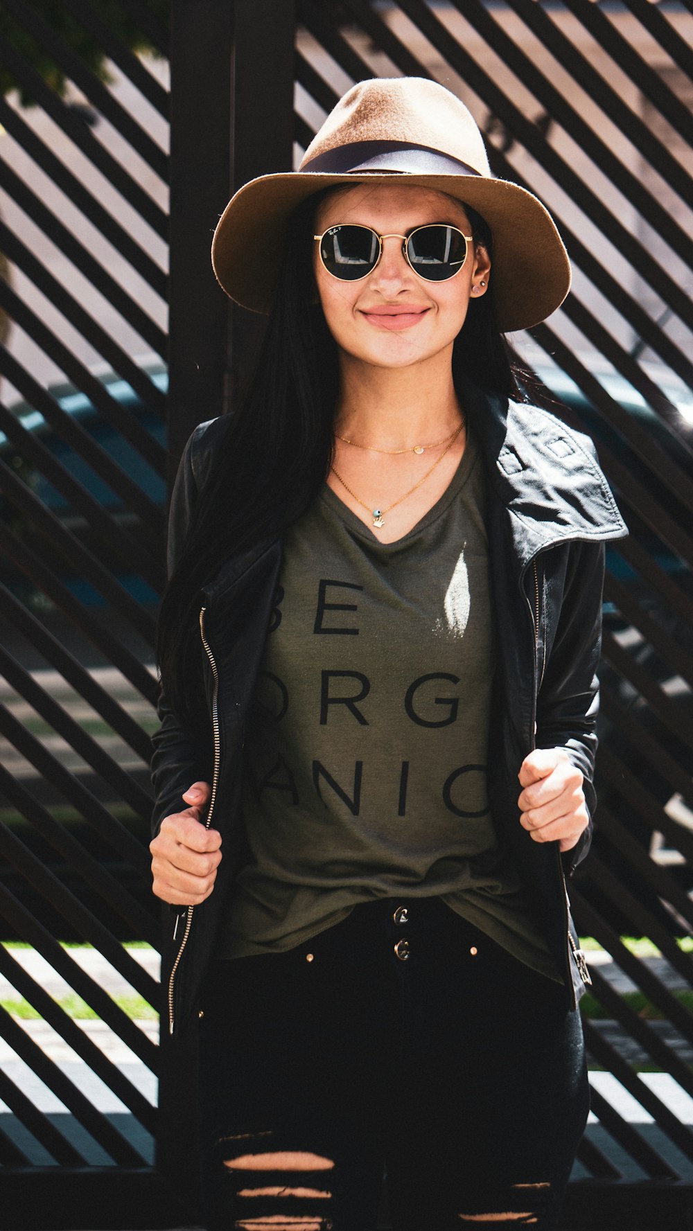 smiling woman while holding hear jacket with both hands