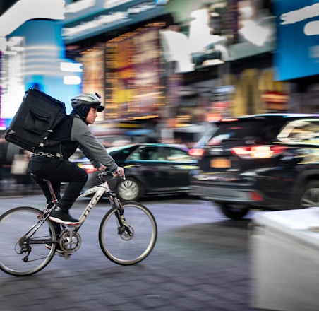 man riding bicycle near vehicles