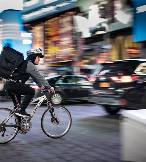 man riding bicycle near vehicles