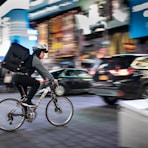 man riding bicycle near vehicles