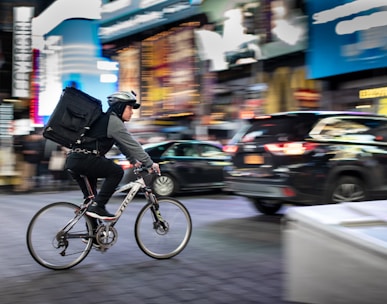 man riding bicycle near vehicles