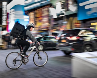 man riding bicycle near vehicles