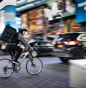 man riding bicycle near vehicles