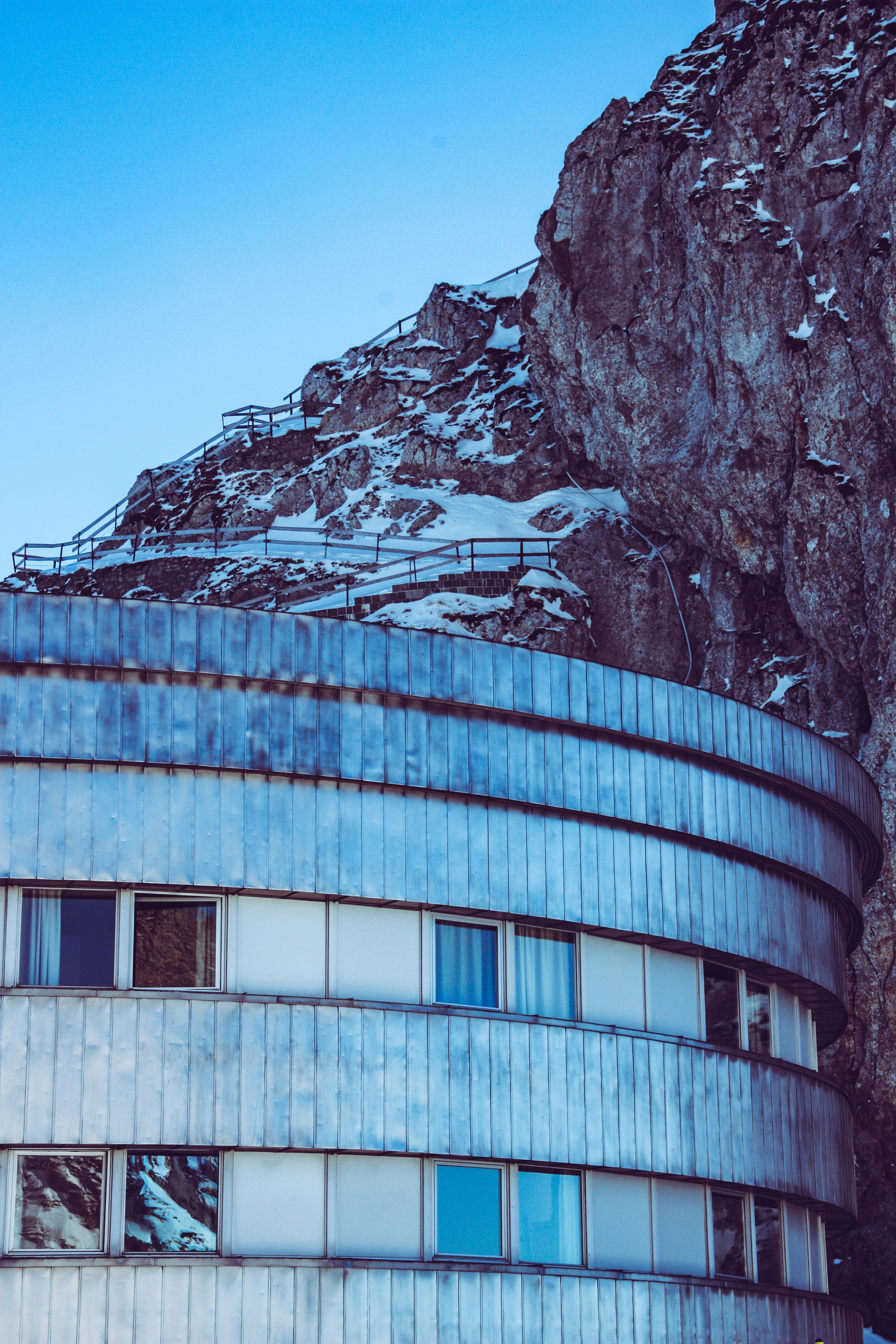Concrete building beside rock photo – Free Blue Image on Unsplash