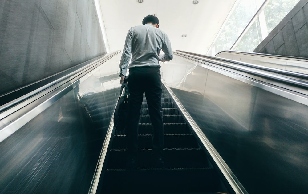 man standing on escalator