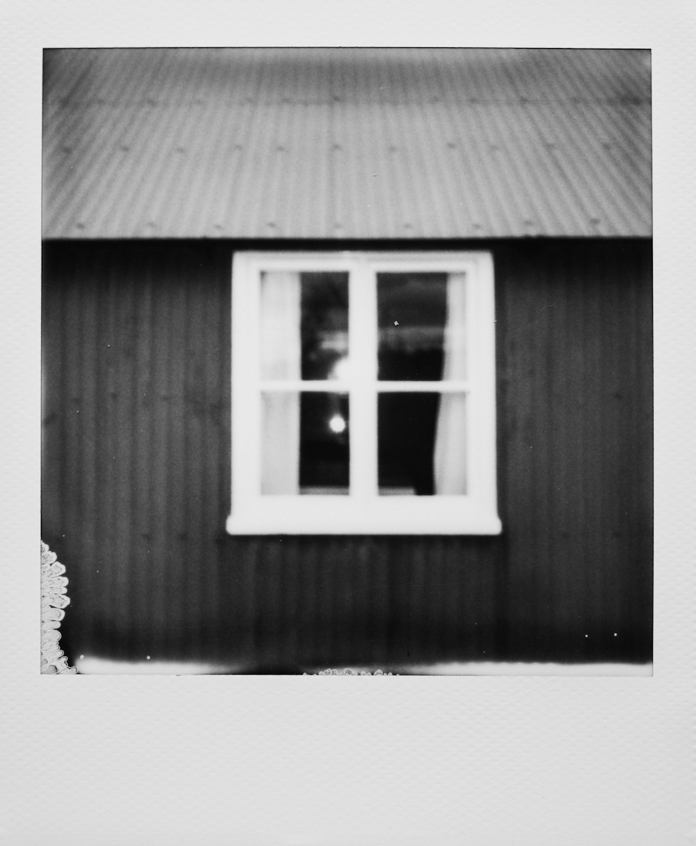 grayscale photo of window with white wooden frame