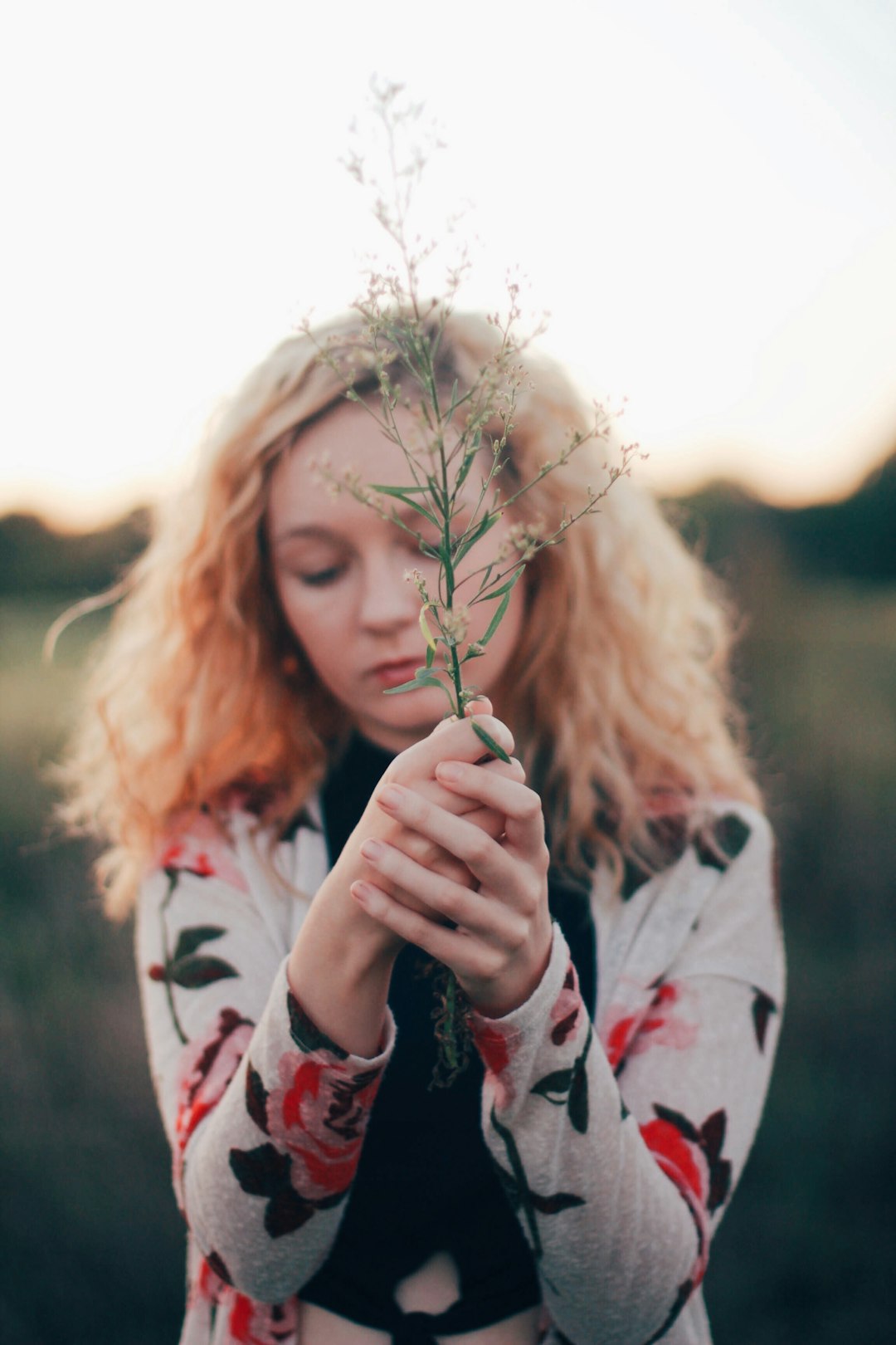 selective focus photo of woman holding white flower