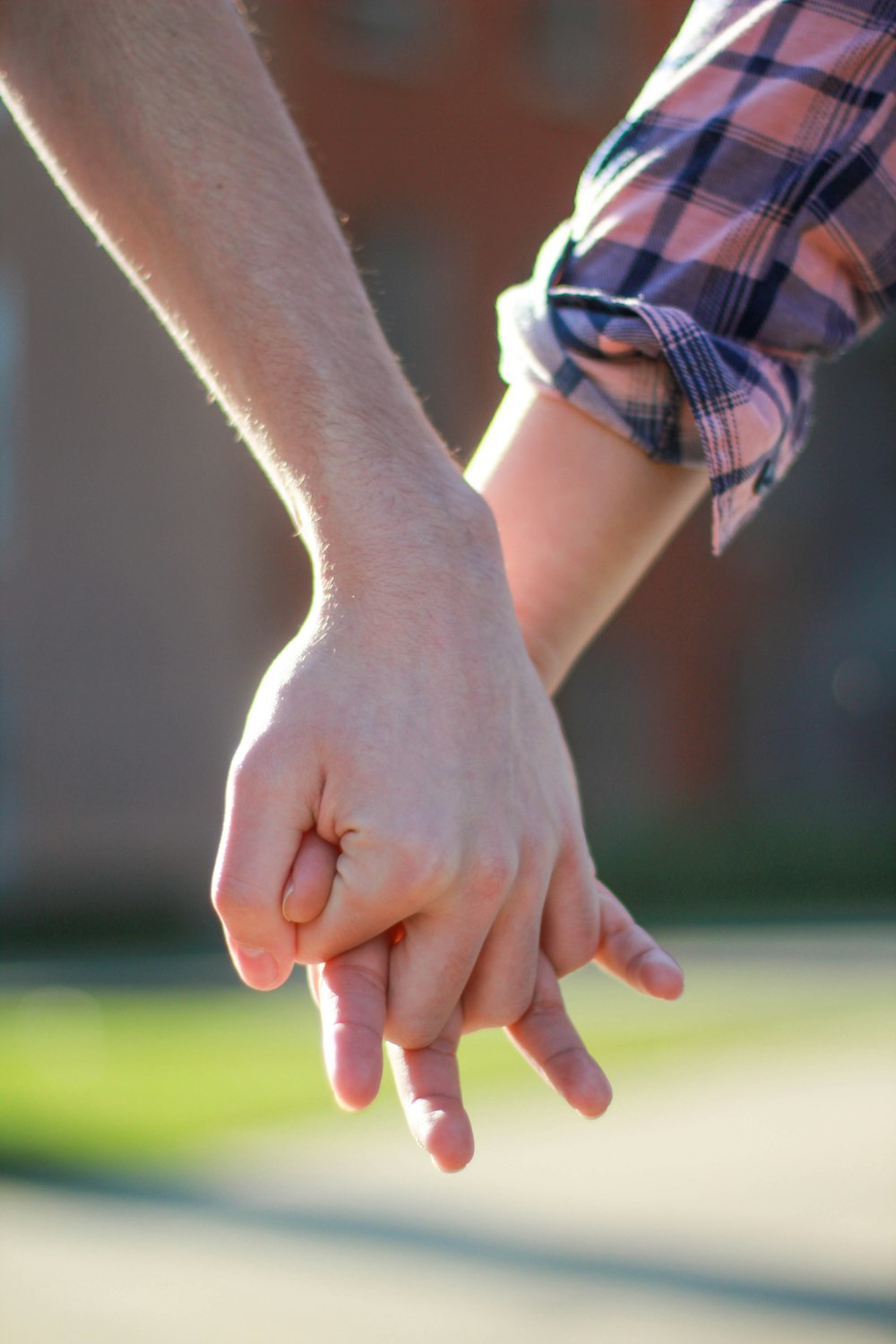 손을 잡고 있는 두 사람의 선택적 초점 사진