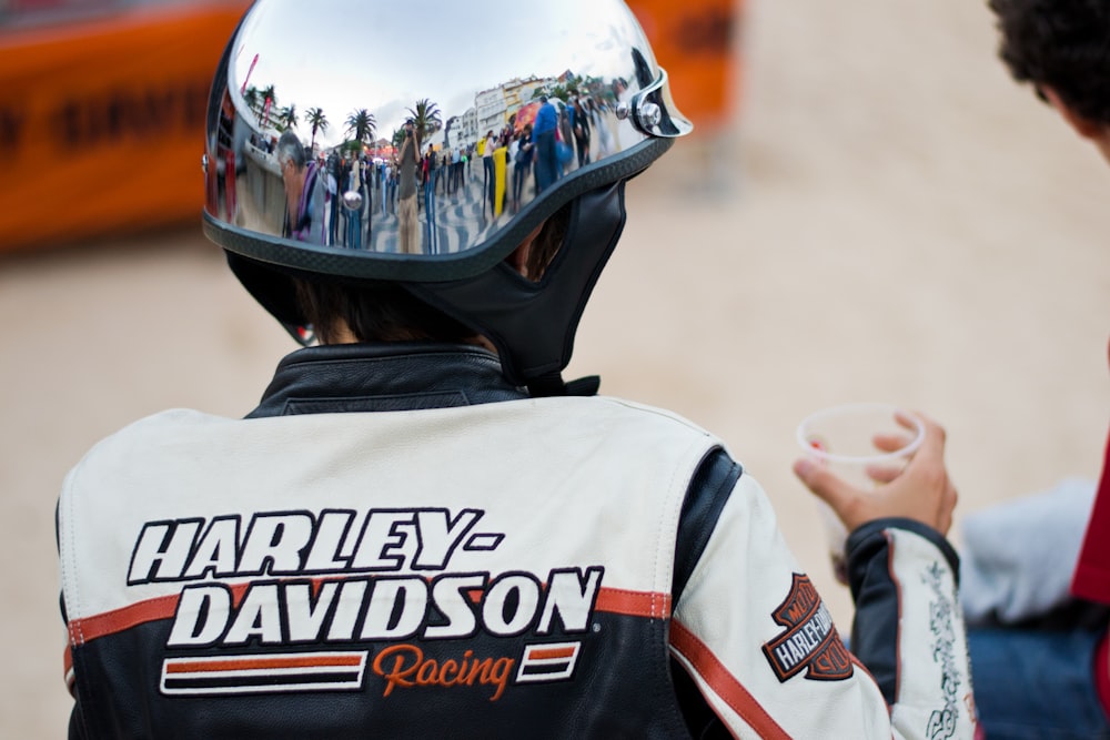 person wearing white and blue Harley-Davidson jacket