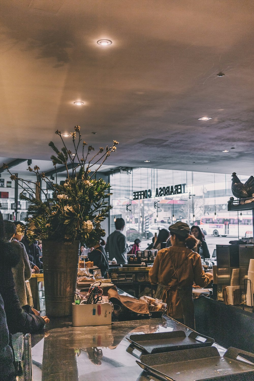 woman standing beside table in Terabosa Cafe during daytime