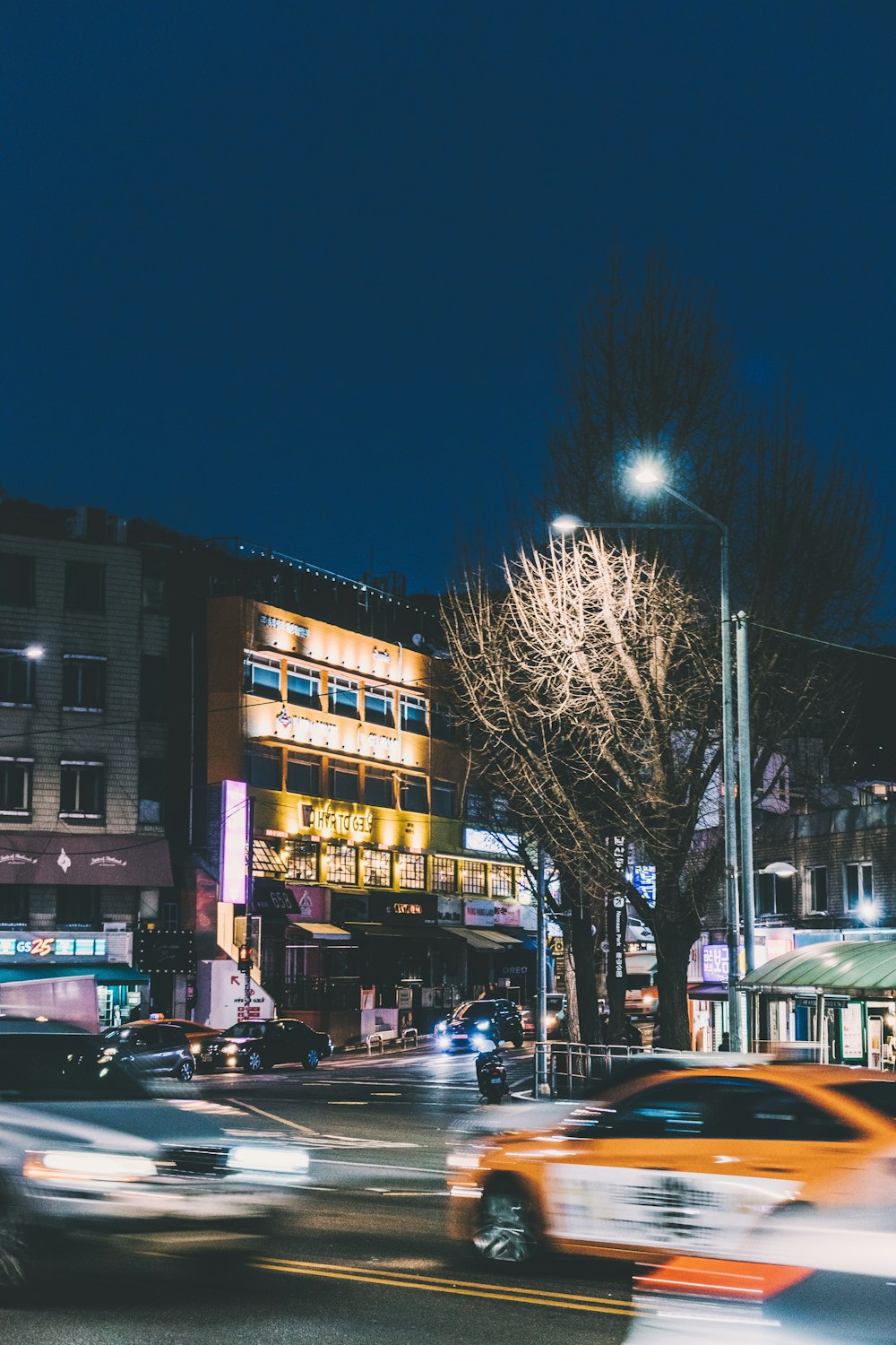 vehicles passing by buildings at night