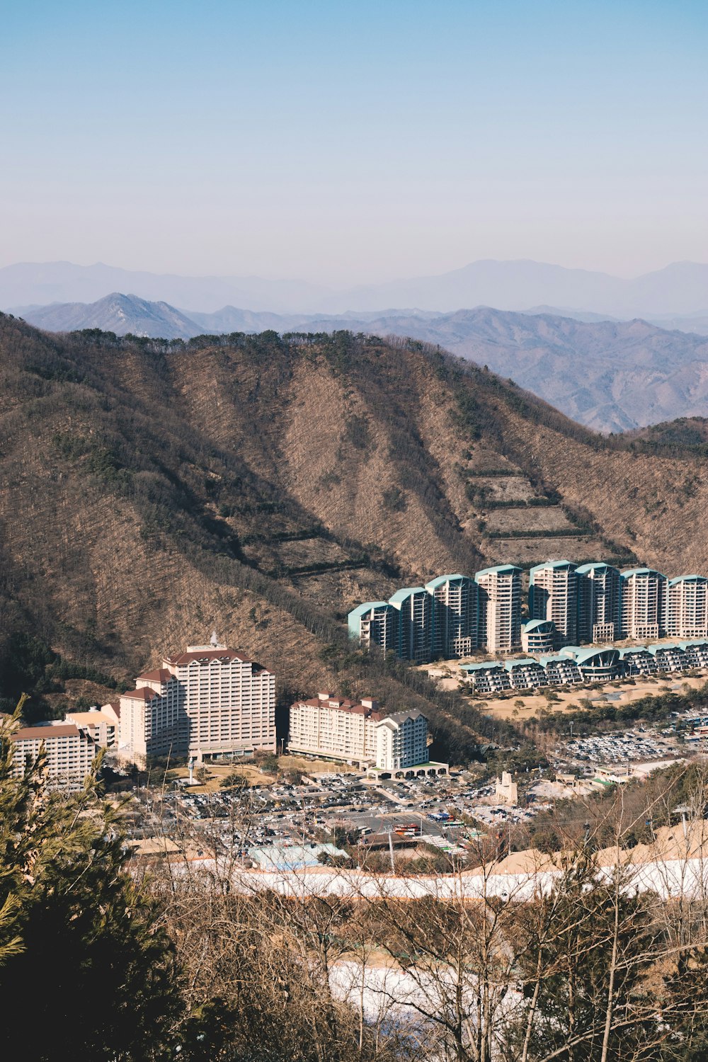 Fotografía aérea de edificios de hormigón de gran altura cerca del pie de la colina durante el día
