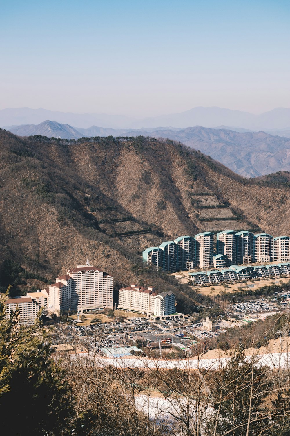 aerial photography of high-rise concrete buildings near at the foot of the hill during daytime