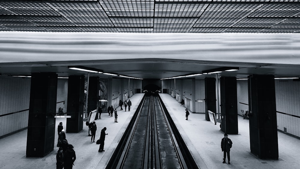 people standing inside subway waiting for train