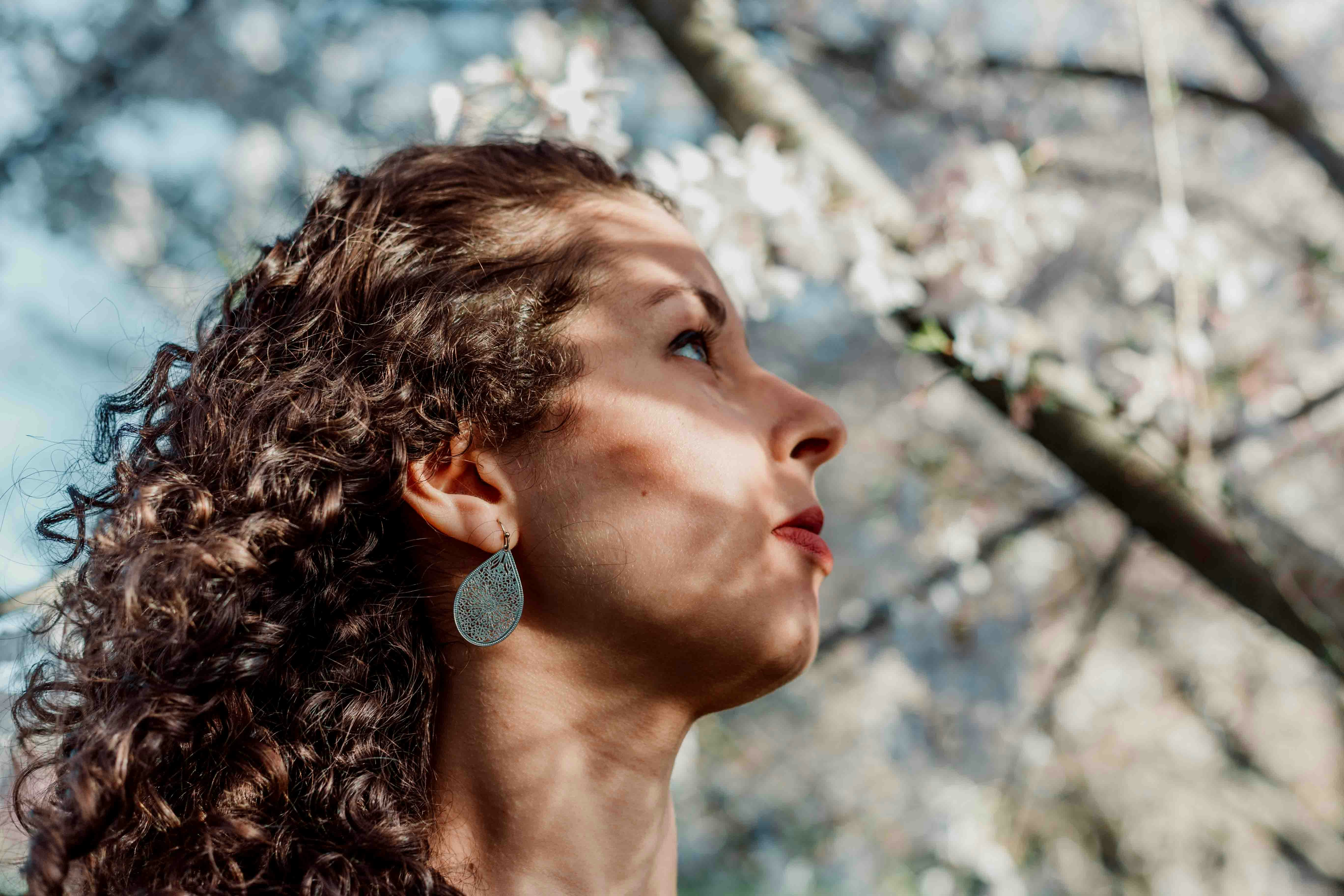 Woman looking through the flowered trees.