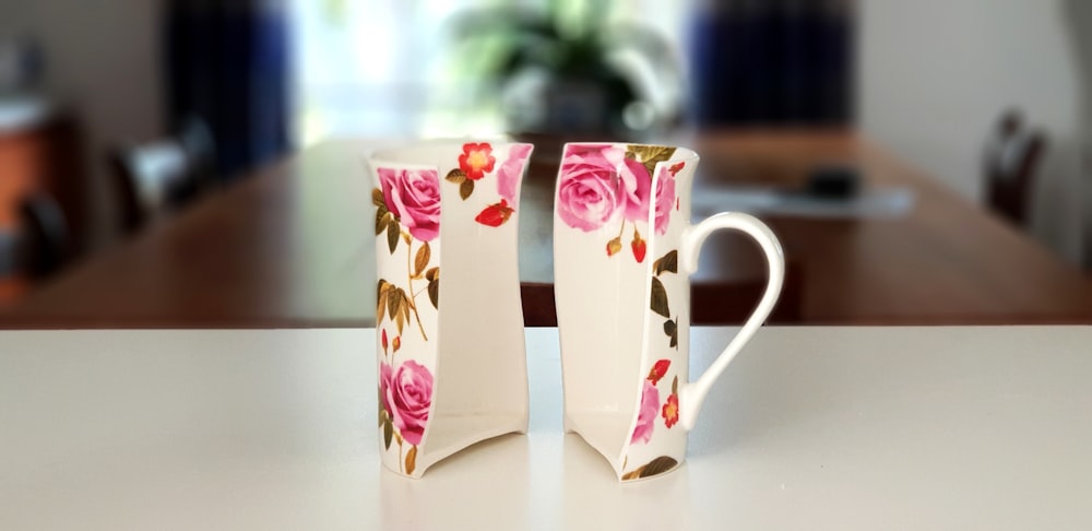 pink and white floral half ceramic mug on top of table