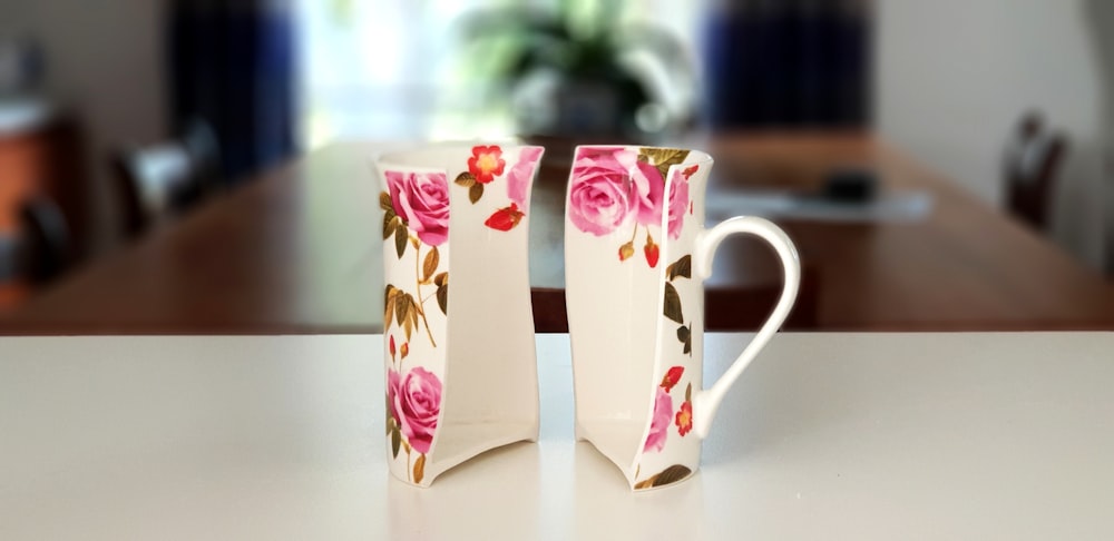 Media taza de cerámica floral rosa y blanca en la parte superior de la mesa