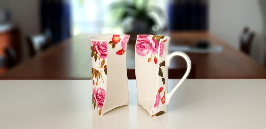 pink and white floral half ceramic mug on top of table, Floral mug split vertically